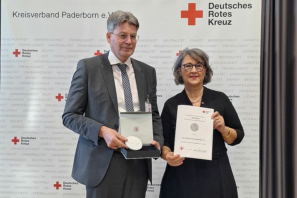 Nilgün Özel überreichte Dr. Lambert Löer die Henry-Dunant-Plakette des DRK-Bundesverbandes zum 150-jährigen Bestehen des DRK-Kreisverbandes Paderborn.